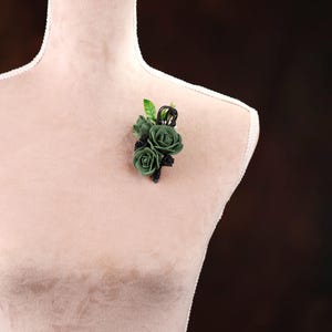 a white mannequin with a green flower on it