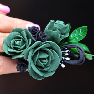 a woman's hand holding a ring with flowers on it