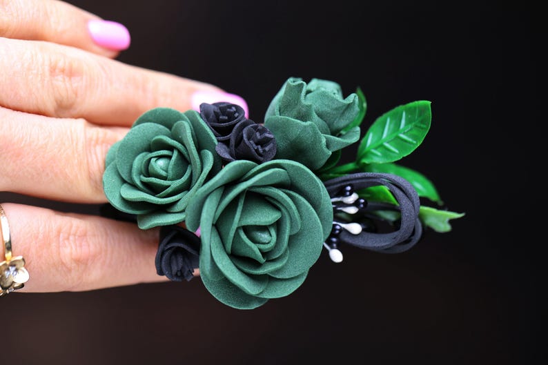a woman's hand holding a ring with flowers on it