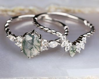 Op de afbeelding: Een zilveren ring met een groene mosagaat-edelsteen en kleine heldere stenen. De ring is gedraaid en heeft een delicaat ontwerp.