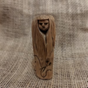 A figurine of three women as a symbol of fate. Wood carving.