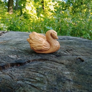 Swan statue carved from wood by hand. A wooden swan figurine that brings the quiet grace of the lake spirit and the warmth of handmade peace