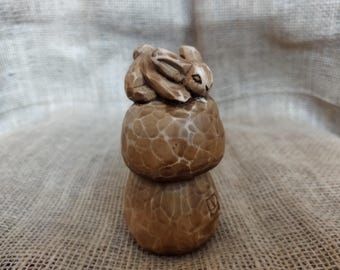 Coniglio su un fungo. Statuetta in legno realizzata a mano. Intaglio del legno.