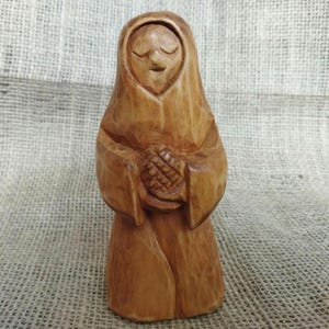 Makosh statue carved from wood by hand. A wooden Slavic goddess figurine, symbol of destiny, abundance, and the ancient protective power.