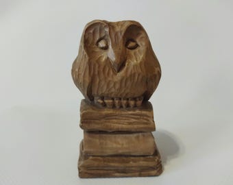 Gufo sui libri, intaglio in legno. Decorazione fiabesca.