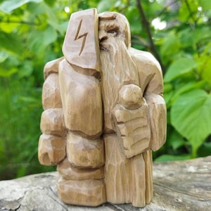 Odin statue. Handmade wooden statue of the god Odin. Scandinavian mythology. Wood carving.