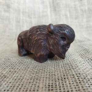 Statua di bisonte. Statua di bisonte in legno fatta a mano. Intaglio del legno.