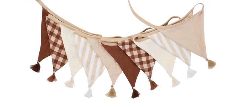 May include: A fabric bunting banner featuring a series of triangular pennants in alternating patterns and solid colors. The design includes brown gingham checks, solid brown, cream, and cream-and-white stripes, each finished with a small tassel.