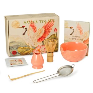 May include: Matcha tea set with a box featuring a crane illustration. The set includes a coral-colored bowl, whisk, sifter, scoop, and a recipe guide. The box reads "Matcha Tea Set".