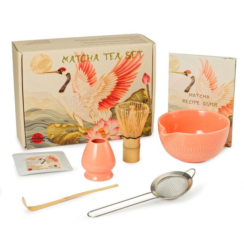 May include: Matcha tea set with a box featuring a crane illustration. The set includes a coral-colored bowl, whisk, sifter, scoop, and a recipe guide. The box reads "Matcha Tea Set".