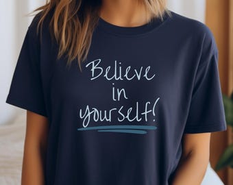 May include: A navy blue t-shirt with the text "Believe in yourself!" in white lettering.