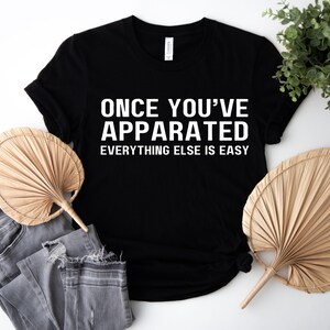Puede incluir: Camiseta negra con texto blanco que dice "Once you've Apparated Everything Else is Easy".