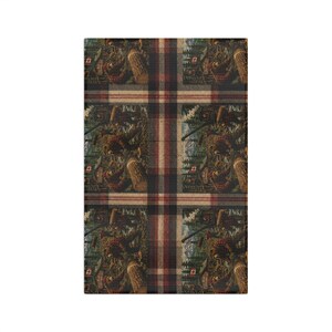 May include: A rectangular fabric textile featuring a repeating pattern of a lumberjack in a red plaid shirt working in a forest with a Canadian flag. The design is overlaid with a dark red, black, and beige plaid grid pattern throughout the surface.