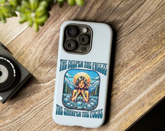 May include: A white phone case with a colorful illustration of a woman in a body of water with ice cubes. The text "The Deeper The Freeze The Sharper The Focus" is printed on the case.