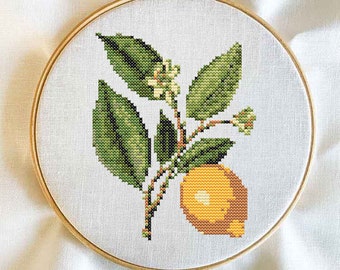 May include: A cross-stitch embroidery hoop with a lemon branch design. The lemon is yellow with green leaves and white blossoms.