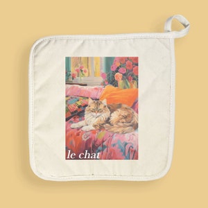 May include: Off-white pot holder featuring a colorful illustration of a cat lying on a floral patterned couch. The image includes an orange pillow, a window, and the text "le chat" in white.