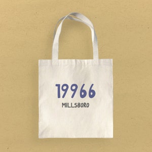 May include: White canvas tote bag with blue text that reads "19966 MILLSBORO".