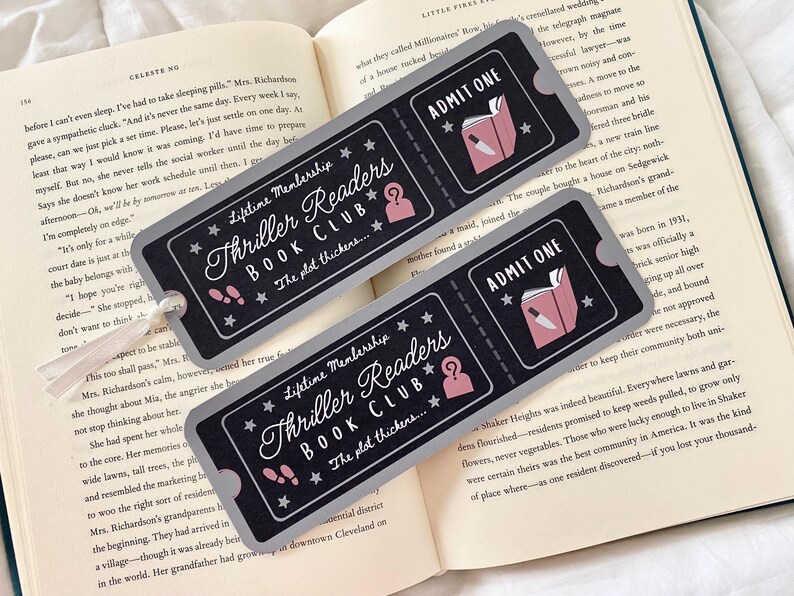 Op de afbeelding: Twee grijze en zwarte boekenleggertickets met een roze en witte illustratie van een boek en een mes. De tekst op de boekenleggers luidt "Lifetime Membership Thriller Readers Book Club... Het plot verdikt..." en "Toegang".