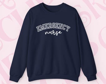 May include: A navy blue sweatshirt with the words "EMERGENCY nurse" printed in white. The word "EMERGENCY" is in a collegiate font, and "nurse" is in a cursive font. The sweatshirt has long sleeves and a crew neck.