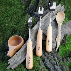 May include: Four wood carving tools with wooden handles and metal blades, along with a wooden spoon and a wooden cup. The tools are labeled "STRYI".