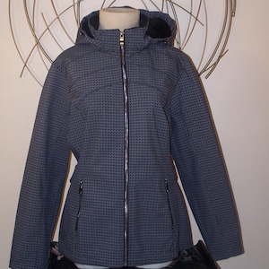 May include: A gray and black patterned jacket with a zipper closure and a hood. The jacket has two zippered pockets on the front.