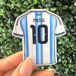 May include: A set of three ceramic mugs with a speckled, matte finish. The mugs are in shades of cream, light gray, and dark gray. Each mug has a simple, minimalist design and a rounded handle. Perfect for coffee or tea.