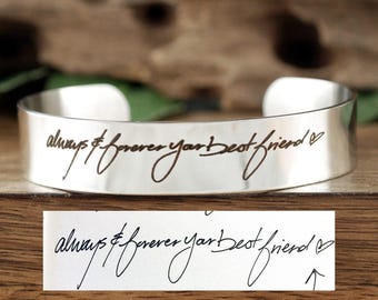 May include: Silver cuff bracelet with the handwritten message "always & forever your best friend" engraved on it.