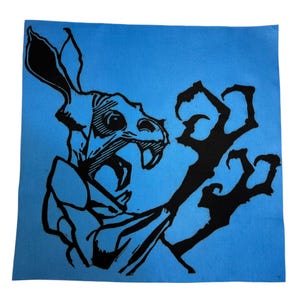 Puede incluir: Ilustración en blanco y negro de una criatura con rostro de calavera y garras afiladas sobre fondo azul. La criatura tiene orejas grandes y boca abierta con dientes visibles. Las garras se extienden.