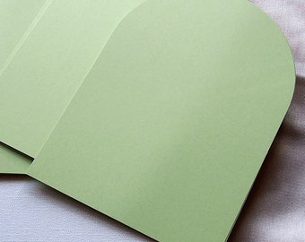 May include: A stack of light green cardstock paper with rounded edges. The top sheet is shaped like an arch.