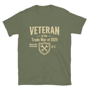 Könnte beinhalten: Olivgrünes T-Shirt mit dem Text "VETERAN of the Trade War of 2025". Darunter ein Schild mit gekreuzten Schraubenschlüsseln und den Worten "Honorable Discharge: 6-3."
