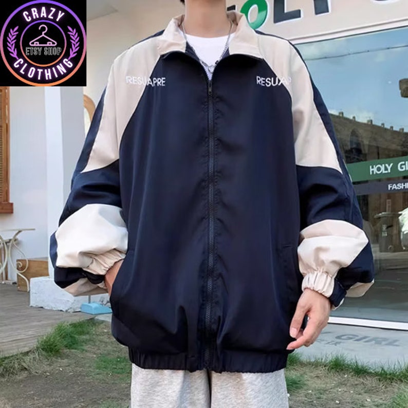 Op de afbeelding: Marineblauwe en beige jas met ritssluiting en het woord "RESUAPRE" op de borst gedrukt. De jas heeft een hoge kraag en lange mouwen. Het Crazy Clothing Etsy Shop-logo staat linksboven.