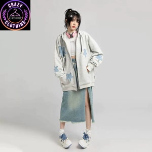 May include: A light gray zip-up hoodie with blue star patches, paired with a denim skirt and white sneakers. The hoodie has a black zipper and a hood. The sneakers have blue star accents. The image includes the text "Crazy Clothing".