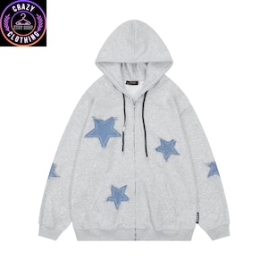 May include: A light gray zip-up hoodie with a hood and blue star patches. The hoodie has a black zipper and a small logo on the sleeve. The Crazy Clothing Etsy Shop logo is in the upper left corner.
