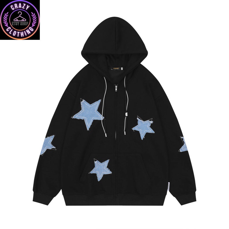 May include: Black zip-up hoodie with light blue star patches. The hoodie features a drawstring hood, a front zipper, and two front pockets. The stars are made of denim material and are sewn onto the black fabric. The Crazy Clothing Etsy Shop logo is in the upper left corner.