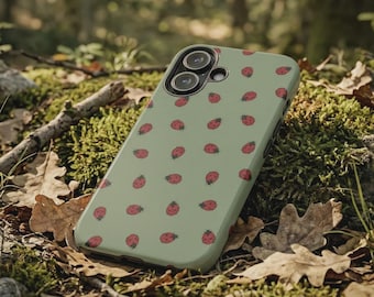 Puede incluir: Funda de teléfono verde claro con un patrón de mariquitas rojas. La funda se muestra sobre musgo, hojas y ramitas, lo que sugiere un tema inspirado en la naturaleza. La funda tiene un recorte para la cámara.