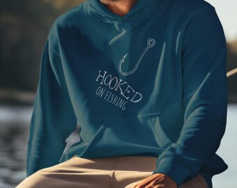 Könnte beinhalten: Ein tealblauer Hoodie mit einem weißen Angelhaken und dem Text "HOOKED ON FISHING" auf der Vorderseite.