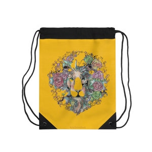 May include: Yellow drawstring bag with a black top and a lion's face surrounded by colorful flowers and vines. The text "Art by Victoria Crowley" is at the bottom of the bag.