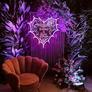 Peut inclure: Une enseigne au n&eacute;on en forme de c&oelig;ur avec un motif de toile d'araign&eacute;e. L'enseigne est &eacute;clair&eacute;e d'une couleur violette vive et porte le texte "Lindsey & Ryan 03.12.2025".