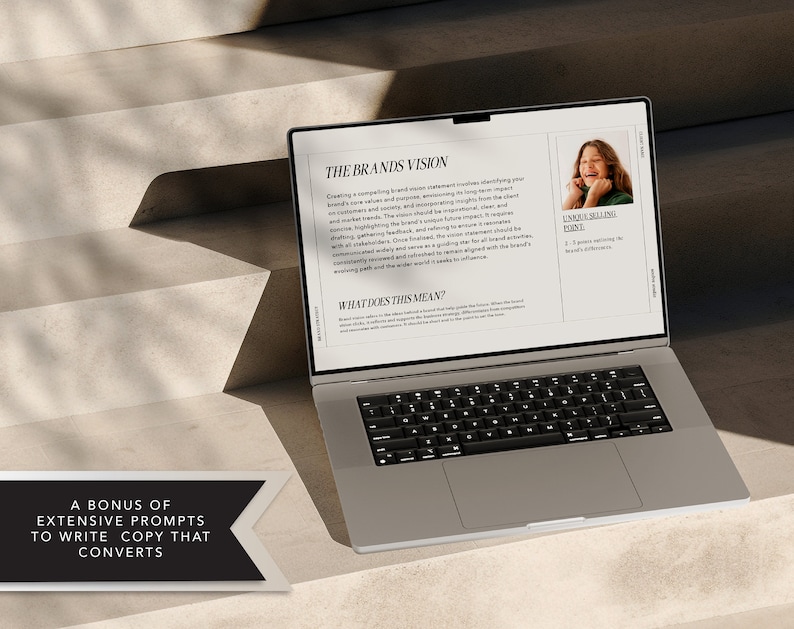 May include: A laptop computer open to a page with the title "The Brands Vision" and a section titled "What Does This Mean?" The page also includes a photo of a young woman smiling. The text on the page discusses creating a compelling brand vision statement.