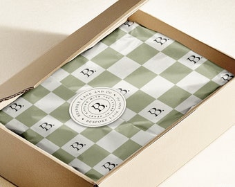 May include: A brown cardboard box with a green and white checkered paper lining. The box has a round sticker with the text "BESPOKE LANE AND CO. GUTTING WITH THE HEART AT EVERY TURN BESPOKE LANE" and a stylized "B" logo.