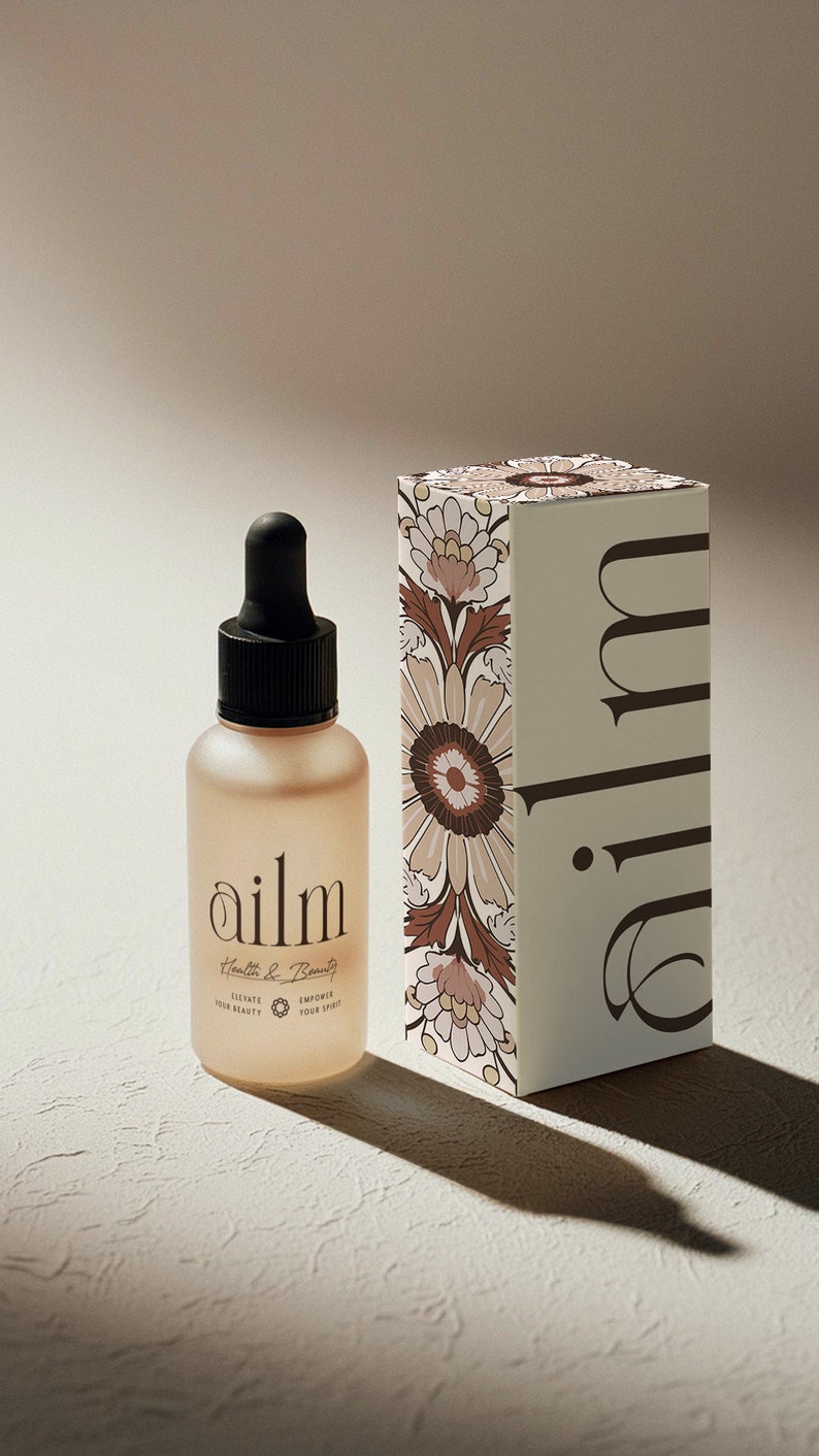 Może przedstawiać: Szklana butelka z przezroczystym, jasnobrązowym płynem i czarną pipetą. Butelka jest oznaczona etykietą "ailm Health & Beauty" i ma kwiatowy wz&oacute;r na etykiecie. Butelka stoi na jasnobrązowej powierzchni obok białego pudełka z kwiatowym wzorem i napisem "ailm" nadrukowanym na boku.