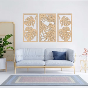 May include: Three wooden wall decor panels with a tropical leaf design. The panels are light brown and feature cut-out designs of monstera leaves and palm fronds.