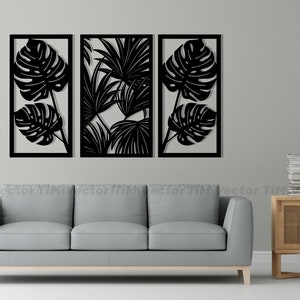 May include: Three black metal wall decor panels with cut-out tropical leaf designs. The panels are arranged in a row on a white wall above a gray sofa.