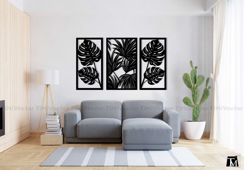 May include: Three black metal wall decor panels featuring cut-out designs of tropical leaves. The panels are arranged in a row on a white wall above a gray couch.