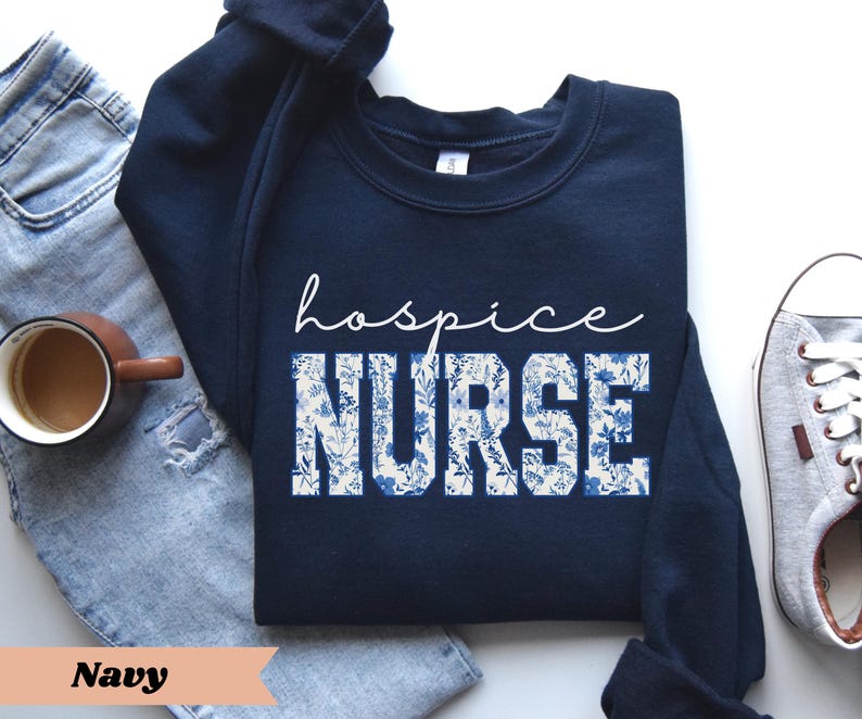 May include: Navy blue sweatshirt with white floral print and the text "hospice nurse" in white.