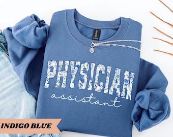 May include: Indigo blue sweatshirt with a white floral design that reads "PHYSICIAN assistant".