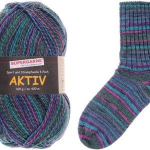 May include: A ball of Aktiv yarn and a matching sock. The yarn is a mix of teal, purple, and blue. The sock has horizontal stripes of the same colors. The yarn label reads "SUPERGARNE AKTIV 100 g / ca. 420 m."