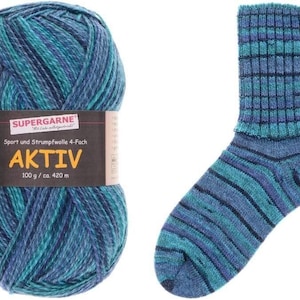 May include: A ball of blue and teal variegated yarn next to a matching sock. The yarn label reads "SUPERGARNE AKTIV" and indicates 100g / ca. 420 m. The sock features a ribbed cuff and striped pattern in shades of blue and teal.