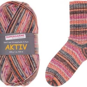 May include: A ball of Aktiv Supergarne yarn and a matching sock. The yarn is multi-colored with shades of pink, orange, brown, and gray. The sock has a ribbed design and is made from the same yarn. The label on the yarn ball reads "Aktiv" and "100 g / ca. 420 m".