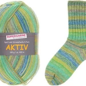 May include: A ball of green, blue, and yellow Aktiv yarn next to a matching sock. The yarn label reads "SUPERGARNE AKTIV 100 g/ca. 420 m". The sock is ribbed and shows the same color pattern as the yarn.
